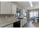 Bright kitchen with white cabinets, black appliances, stainless steel sink and a view of the dining area at 3153 Morgan Box Ne Ln, Buford, GA 30519