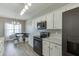 Bright kitchen with white cabinets, granite countertops, black appliances, and a view of the dining area at 3153 Morgan Box Ne Ln, Buford, GA 30519