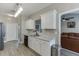 Stylish kitchen features white cabinets, black appliances, stainless steel sink and a view to the living room at 3153 Morgan Box Ne Ln, Buford, GA 30519