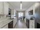 Spacious kitchen with white cabinets, granite countertops, black appliances, view of dining area, and modern lighting at 3153 Morgan Box Ne Ln, Buford, GA 30519