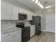 Well-lit kitchen with white cabinets, granite countertops, stainless steel appliances, and modern lighting at 3153 Morgan Box Ne Ln, Buford, GA 30519