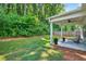 Inviting backyard featuring a covered patio with stylish furniture, surrounded by lush greenery at 165 Winner St, Acworth, GA 30102