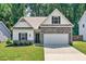 Charming single-Gathering home features a stone facade, attached two-car garage, and a well-manicured front lawn at 165 Winner St, Acworth, GA 30102