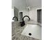 Granite countertop in bathroom with stainless steel faucet and decorative lighting, complemented by tiled flooring at 2147 Saint Albans Pl, Buford, GA 30519
