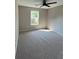 Bedroom features a window, ceiling fan, and carpeted flooring at 2147 Saint Albans Pl, Buford, GA 30519
