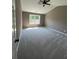 A bright bedroom with a ceiling fan, a window providing natural light, and soft, neutral carpeting at 2147 Saint Albans Pl, Buford, GA 30519