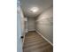 A walk-in closet featuring built-in white shelving and wood-look flooring for organized storage at 2147 Saint Albans Pl, Buford, GA 30519