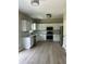 Eat-in kitchen featuring stainless steel appliances, white cabinets, and hardwood floors at 2147 Saint Albans Pl, Buford, GA 30519
