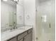 Bright bathroom features a marble countertop, gray cabinetry, and glass shower door at 304 Stonemont Dr, Atlanta, GA 30305