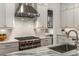 Modern kitchen features stainless steel range hood, gas range, backsplash and an island with seating at 304 Stonemont Dr, Atlanta, GA 30305