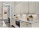 Bright kitchen features white cabinets, marble countertops, under cabinet lighting and a unique wallpaper feature wall at 304 Stonemont Dr, Atlanta, GA 30305