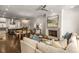 Open-concept living room with modern fireplace, hardwood floors, and a stylish chandelier, seamlessly blending into the kitchen at 304 Stonemont Dr, Atlanta, GA 30305