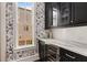 Stylish butler's pantry area with black cabinets, marble countertops, wine cooler and unique wallpaper at 304 Stonemont Dr, Atlanta, GA 30305