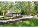This outdoor space features a stone patio area surrounded by beautiful green grass and mature trees at 3200 Lowndes St, East Point, GA 30344