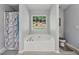 Bright bathroom showcasing a large soaking tub under a window for plenty of natural light at 672 Victorian Cir, Dallas, GA 30157