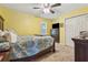 Bright bedroom featuring yellow walls, carpet floors, ceiling fan and a double door closet at 672 Victorian Cir, Dallas, GA 30157