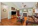 Cozy living room with a fireplace, hardwood floors, vaulted ceiling, and large windows offering plenty of natural light at 672 Victorian Cir, Dallas, GA 30157