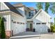 Attached garages with white carriage style doors complement the light gray siding at 2208 Sage Mountain Sw Ct, Marietta, GA 30064