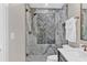 Luxurious shower with marble tile surround, frameless glass doors, and modern fixtures at 230 Thistlewood Ln, Roswell, GA 30075