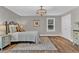 Bedroom with neutral walls and wood floor, featuring a decorative rug and chandelier at 230 Thistlewood Ln, Roswell, GA 30075