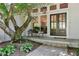 Charming front entrance with stained wood double doors, a picturesque tree, and stylish outdoor seating at 230 Thistlewood Ln, Roswell, GA 30075