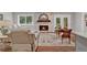 Cozy living room featuring a stone fireplace, wood floors, and access to outdoor living at 230 Thistlewood Ln, Roswell, GA 30075