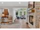 Cozy living room with a stone fireplace and a view into a sunroom at 230 Thistlewood Ln, Roswell, GA 30075