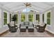 A bright sunroom with vaulted ceiling, many windows, and comfortable wicker seating arrangement at 230 Thistlewood Ln, Roswell, GA 30075