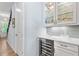 Elegant bar area with custom cabinets, wine refrigerator, and glass shelving at 4486 Huffman Drive Ne Dr, Roswell, GA 30075
