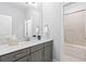 Neutral bathroom featuring granite countertop, gray cabinets, framed mirror and a shower/tub combination at 4486 Huffman Drive Ne Dr, Roswell, GA 30075