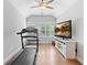 Bright exercise room featuring a treadmill, television, hardwood floors, and plantation shutters at 4486 Huffman Drive Ne Dr, Roswell, GA 30075