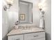 Stylish half bath with granite counter, modern fixtures, and decorative mirror at 4486 Huffman Drive Ne Dr, Roswell, GA 30075