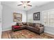 Sitting room with hardwood floors, plantation shutters, ceiling fan, and a brown sectional couch and decorative area rug at 4486 Huffman Drive Ne Dr, Roswell, GA 30075
