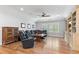 Spacious living room with hardwood floors, ceiling fan, large windows, and a black leather sofa at 4486 Huffman Drive Ne Dr, Roswell, GA 30075