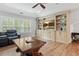 Open living room with hardwood floors, ceiling fan, large windows, and built in cabinet with a television at 4486 Huffman Drive Ne Dr, Roswell, GA 30075