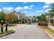 Street view of gated townhome community featuring brick accents and mature landscaping at 4486 Huffman Drive Ne Dr, Roswell, GA 30075