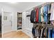 Spacious walk-in closet with built-in shelving and drawers, and view to ensuite bathroom at 4486 Huffman Drive Ne Dr, Roswell, GA 30075