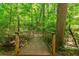 A wooden bridge leads into a beautiful and lush wooded walking trail at 4486 Huffman Drive Ne Dr, Roswell, GA 30075