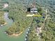 Beautiful aerial view of home near lake access surrounded by lush green trees and boathouses at 5350 Mercedes Dr, Cumming, GA 30041