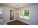 Bright dining area featuring a modern light fixture, wood floors, and large window with natural light at 5350 Mercedes Dr, Cumming, GA 30041