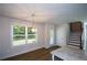 Bright dining area featuring a modern light fixture, wood floors, and large window with backyard views at 5350 Mercedes Dr, Cumming, GA 30041