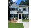 Charming two-story home with white siding, black shutters, and manicured front yard, perfect for Gathering living at 5350 Mercedes Dr, Cumming, GA 30041