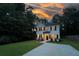 Charming two-story home featuring a manicured lawn, a concrete driveway, and a twilight sky at 5350 Mercedes Dr, Cumming, GA 30041