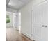 Hallway with wood flooring, white trim, and doors, showcasing access to other areas of the home at 5350 Mercedes Dr, Cumming, GA 30041