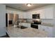 Spacious kitchen features granite countertops, stainless steel appliances, and an island at 5350 Mercedes Dr, Cumming, GA 30041