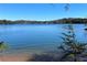 Peaceful lake view with calm water, trees, and clear blue sky, offering a serene escape at 5350 Mercedes Dr, Cumming, GA 30041