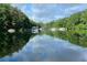 Scenic lake view featuring calm waters, lush greenery, and distant docks under a cloudy sky at 5350 Mercedes Dr, Cumming, GA 30041