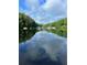 Reflective lake scene with trees and a dock in the background, capturing the peaceful outdoor atmosphere at 5350 Mercedes Dr, Cumming, GA 30041