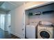 Convenient laundry room featuring a washer, dryer, and shelving for storage at 5350 Mercedes Dr, Cumming, GA 30041
