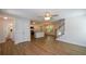 Bright and airy living room flows into the kitchen area with modern stairs and wood flooring at 5350 Mercedes Dr, Cumming, GA 30041